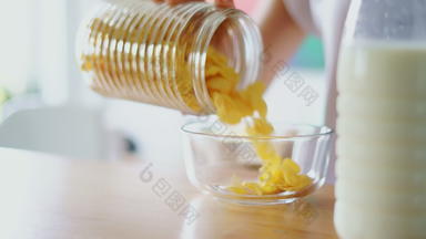 女人手倒玉米片玻璃碗关闭准备谷物